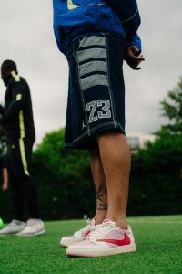Close up of Jordan 23 denim shorts and pink Jordan trainers on the pitch at the activation