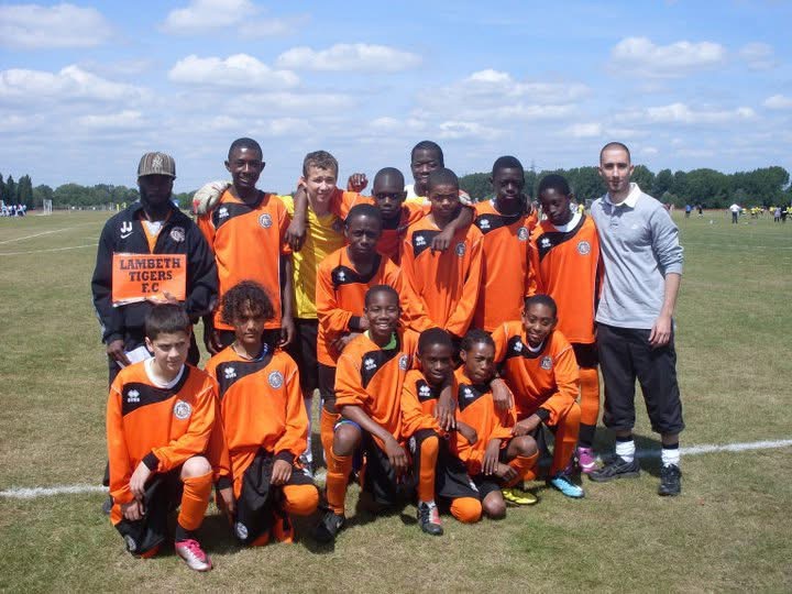 The original Lambeth Tigers youth team posed together on a grass pitch, the grassroots foundation behind The Streetz Football